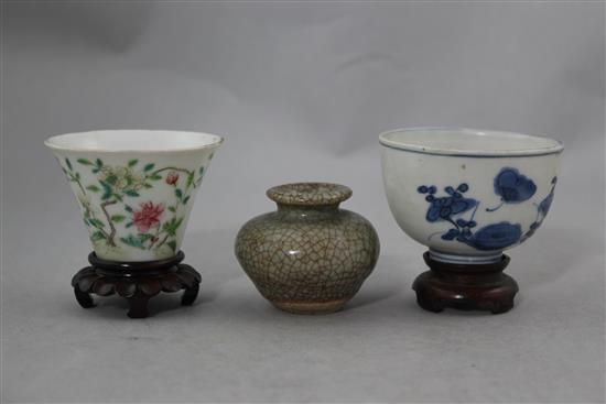 Two Chinese porcelain cups and a small crackle glaze vase, 17th - 19th century, 4.8cm., with wood stand